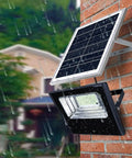 LED-Solarstrahler an einer regenfesten Außenwand installiert - Wasserdichte IP66-Außenbeleuchtung mit integriertem Solarpanel zur Energieeinsparung