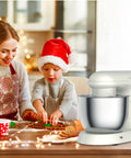 Wintem Küchenmaschine für die Familie an Weihnachten: Mutter und Kind bereiten gemeinsam festliche Süßspeisen in der Küche mit weihnachtlicher Atmosphäre zu