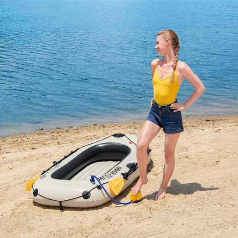 Frau im gelben Badeanzug am Strand mit dem aufblasbaren Battle Bomber-Schlauchboot, demonstriert den einfachen Transport