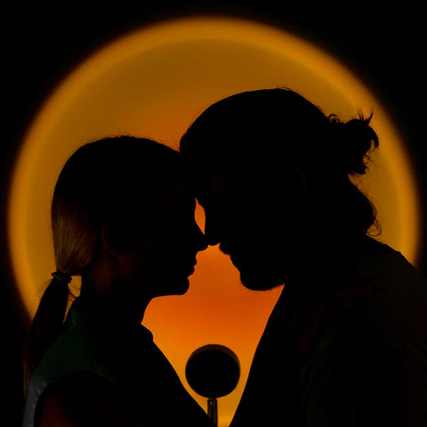 Romantisches Paar als Silhouette mit einem Sonnenuntergangsprojektor, der eine intime und romantische Atmosphäre schafft - perfekt für liebevolle Momente